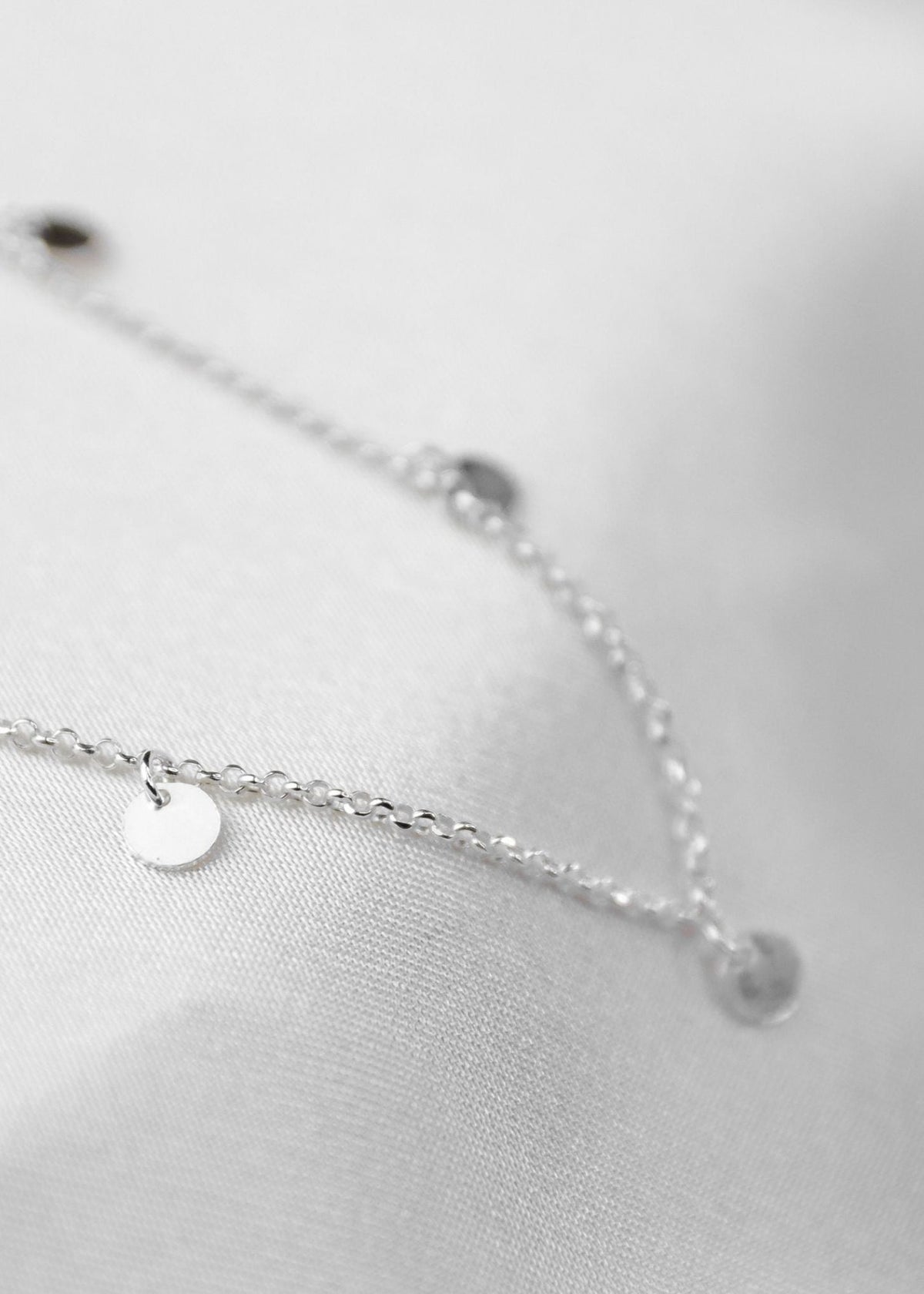 waterproof multi disc necklace on white sheet