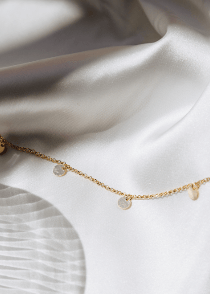 waterproof multi disc necklace on white sheet